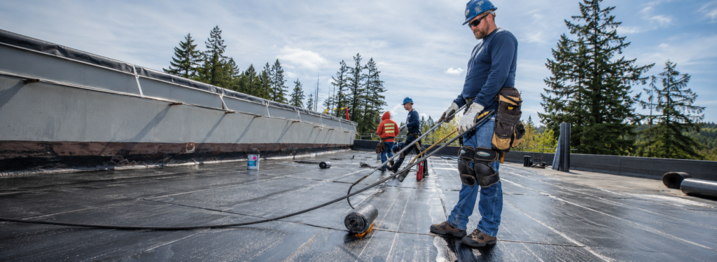 Torch-on flat roofing membrane being applied on a commercial roof